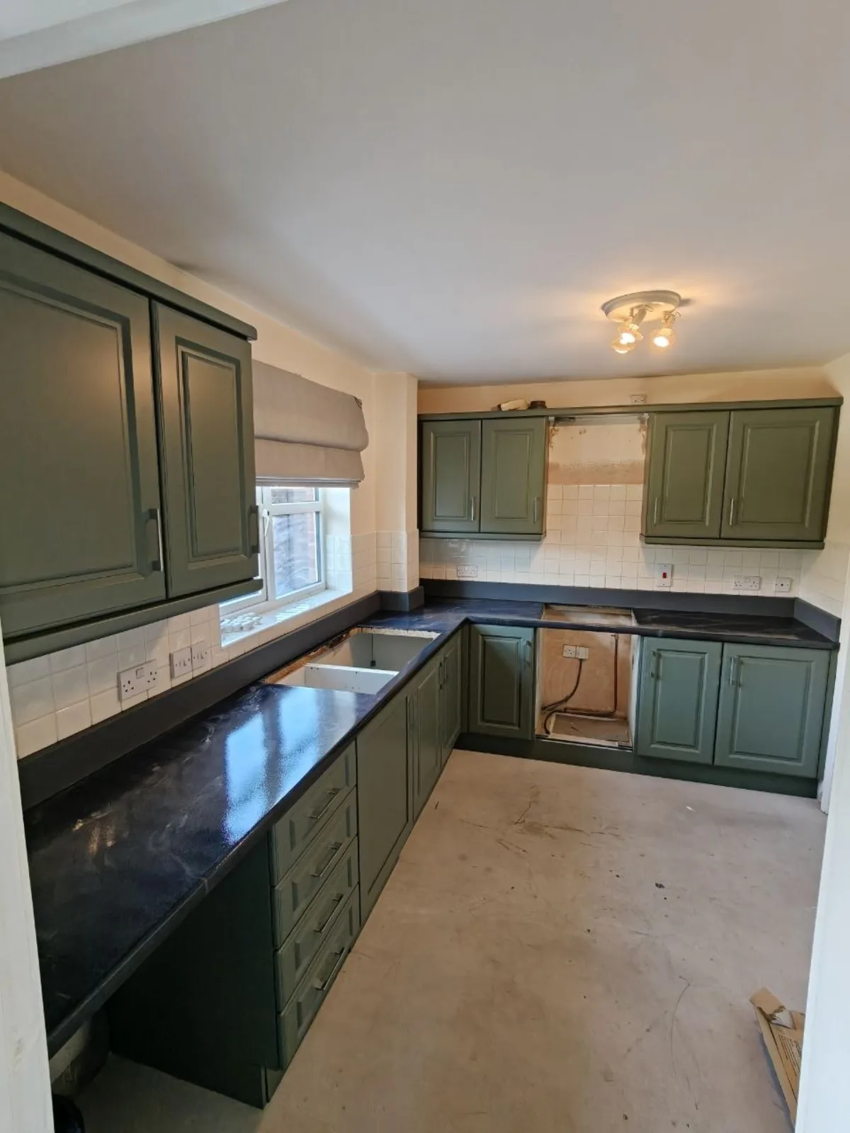 Galley kitchen resprayed forest green with a dark worktop